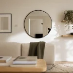 Décorer mur blanc : cadres noirs, étagères flottantes et miroir rond